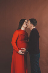 Loving husband holding his wife belly in studio