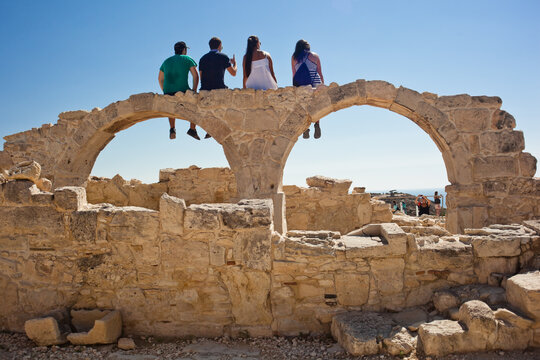 Friends relaxing on a double arch structure at an archaelogic site at Kurion, Cyprus