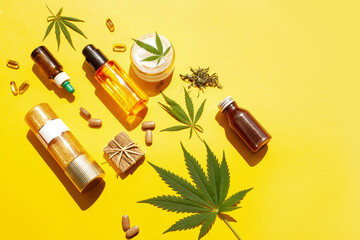Natural cosmetics with cannabis leaves with contrasting shadows. View from above