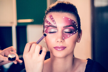 Make-up Artist Applying Powder on Model's Cheeks With Purple Brush