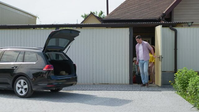 family trip, happy parents with their little cheerful male children go on vacation and leave house with suitcases to load luggage