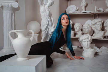 Beautiful young girl with blue hair in the sculptor's studio.