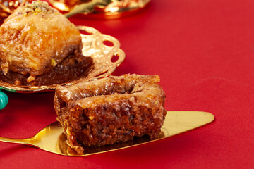 Turkish baklava and coffee in oriental dishware on red background