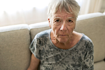 Portrait Of Senior Woman On Sofa Suffering From Depression