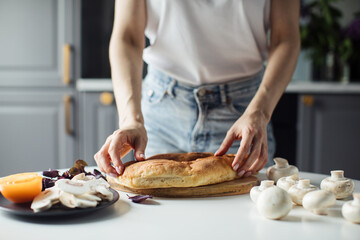 Girl breaks bread with her hands in the bright kitchen. Healthy food.