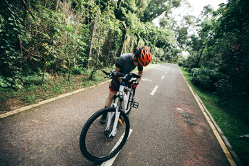 Woman cyclist set the seat of bike  at park on sunny day