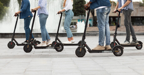 Friends having ride on motorized kick scooters