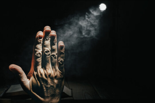 man prayer in the dark against the background of the bible