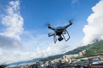 White drone with camera flying in the air