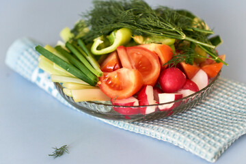 Mix salad from fresh vegetables and greens herbs on the blue napkin. Dietary menu. Proper nutrition. Healthy lifestyle. Copy space.