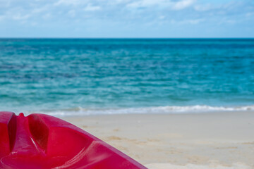 Background of beautiful summer holiday vacation on white clean sand beach clear sea water quite wave with red Kayak boat for fun active activity 