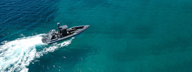 Aerial drone ultra wide photo of rigid inflatable speed boat cruising in deep blue Aegean sea,...