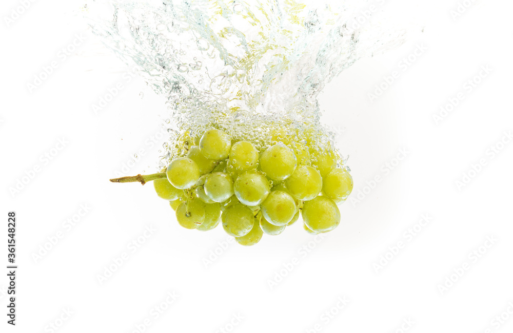 Canvas Prints Bunch of green grapes splashing into crystal clear water with air bubbles. Isolated on a white background.