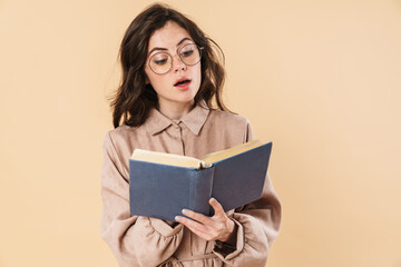 Image of surprised caucasian woman in eyeglasses reading book