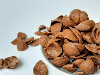 Cocoa crunch cereal or cornflakes, on a small plate. Isolated in white background.