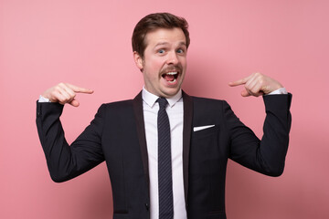 Man proud of himself pointing on his chest over pink background. I am the best concept.