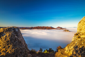 Mountain peaks over misty autumn landscape. Morning inversion in the Sulov rock mountains, Slovakia Europe.