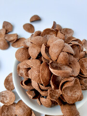 Cocoa crunch cereal or cornflakes, on a small plate. Isolated in white background.