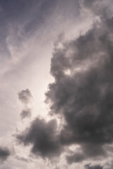 a background of gray atmospheric clouds and a cloud in the shape of a demonic head looking down