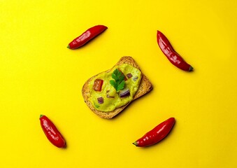 Torradas com guacamole e pimenta em fundo amarelo