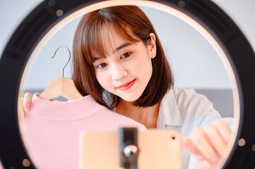 Woman blogging online and streaming live. Asian entrepreneur use social media for business at home....