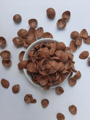 Cocoa crunch cereal or cornflakes, on a small plate. Isolated in white background.