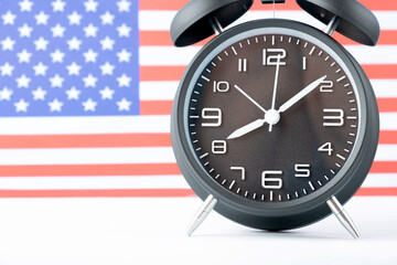 Close up of retro analog clock on USA american flag background.