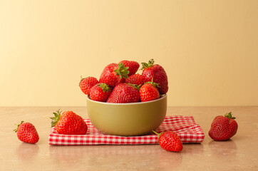 Fresh red strawberries in a bowl on wood table  background and towel