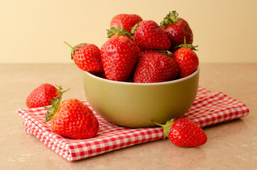 Fresh red strawberries in a bowl on wood table  background and towel