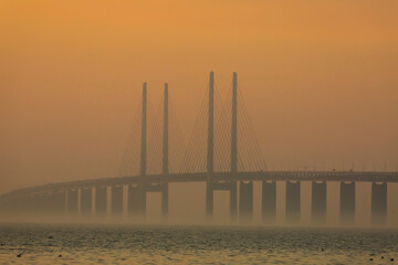 Fototapeta na wymiar The Oresund bridge in a foggy sunset
