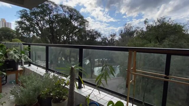 Video de timelapse feito na sacada do pr&eacute;dio com plantas mostrando as nuvens em movimento