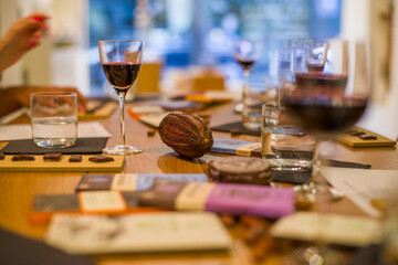 Dark chocolate tasting with wine. Cocoa beans on the table with glasses of red wine