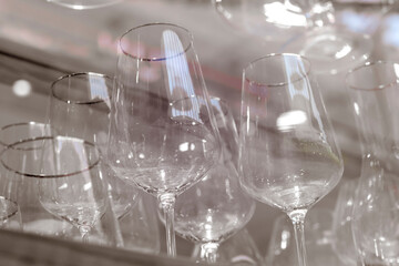 Many transparent wine glasses on a thin high leg in the window of a large cookware store.