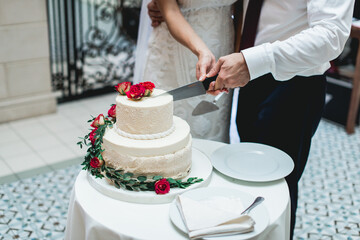 Obraz na płótnie Canvas wedding ceremony. the bride and groom make their first case together, cut the white wedding cake