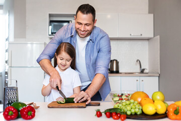 Happy Father And Daughter Cooking Together Cutting Vegetables In Kitchen