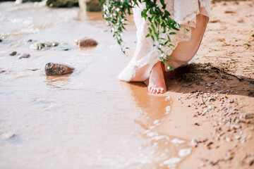 The bride walks along the beach before the wedding