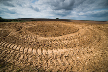 Traces of a tractor on a plowed field. Graphic drawing is not the ground.