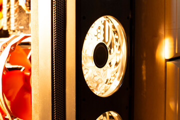 Computer fans in a black case with an orange hue.