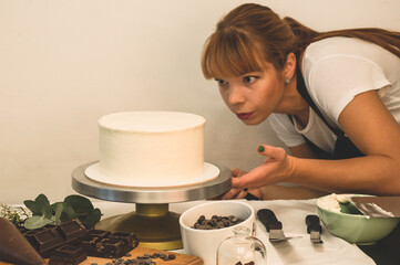 Confectioner girl is preparing a cake. The concept of pastry, cooking cakes