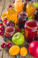 Assortment of berries and fruits jams. Set of various seasonal summer berry and fruit jam, marmalade and confitures. Wooden rustic background copy space