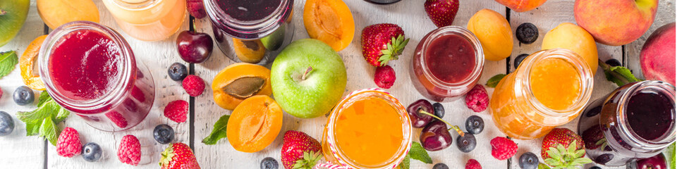 Assortment of berries and fruits jams. Set of various seasonal summer berry and fruit jam, marmalade and confitures. White wooden background copy space