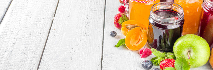 Assortment of berries and fruits jams. Set of various seasonal summer berry and fruit jam, marmalade and confitures. White wooden background copy space