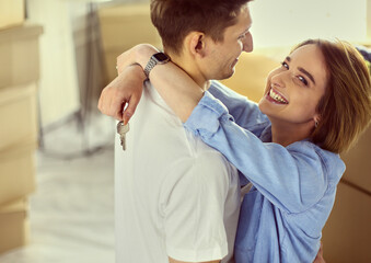 Happy smiling young couple showing a keys of their new house