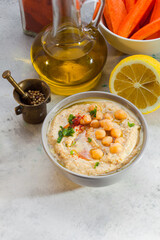 Hummus paste with ingredients on white surface