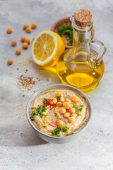 Chickpea hummus with olive oil and lemon on light background