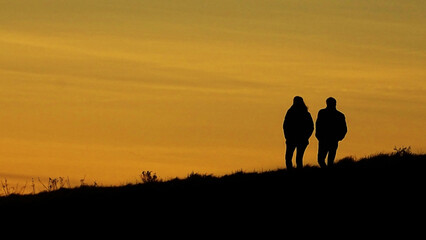 Fototapeta na wymiar Couple walking in the sunset