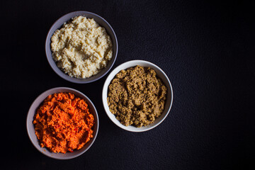 Three bowls with tasty dip souces, black background