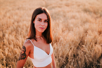 portrait of beautiful woman in a yellow field at sunset. Summer time