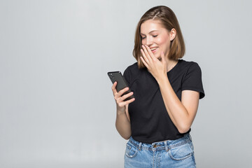 Fototapeta premium Young woman texting on her mobile phone over a white background