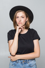 Gorgeous young woman in black floppy hat posing isolated on white background